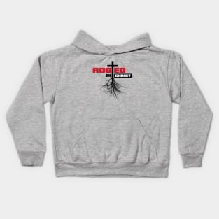 Rooted in Christ with a cross and black text Kids Hoodie